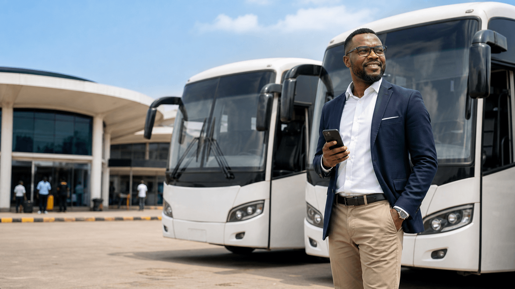 Fleet owner standing beside multiple buses at a terminal